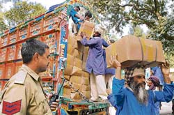 Indian porters unload boxes of fresh melons imported from Afghanistan via Pakistan at the Attari joint checkpost