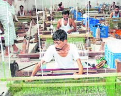 Workers busy in a pit loom factory in Panipat