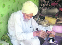 Eighty-year-old �jutti� maker Dalip Singh sits hunch-backed in Muktsar