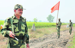 A jawan of the BSF signal to Pakistan Rangers for a flag meeting at zero line