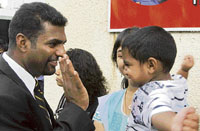 Muttiah Muralitharan shares a light moment with his son in Colombo on Tuesday ahead of the team departure to Australia for two Tests.