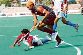 An SAI defender tries to stop Indian Oil forward Prabhjot Singh during a league match of the Surjit Hockey Tournament in Jalandhar