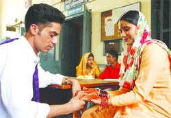 Gurjit Singh admires the mehandi pattern on the hands of his wife Kuldip Kaur in the Central Jail at Bathinda on the occasion of Karva Chauth