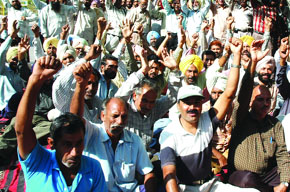 Postal employees staging a dharna in front of the post office in Bathinda on Tuesday.