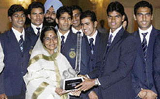Indian Asia Cup hockey captain Prabodh Tirkey (2-R) presents a memento to President Pratibha Patil (2-L) as other players pose for a photograph at the Rashtrapati Bhawan.