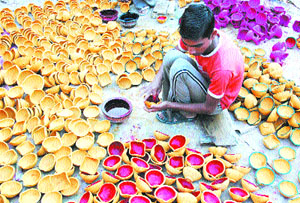 A boy gives final touches to diyas in Amritsar on Friday.