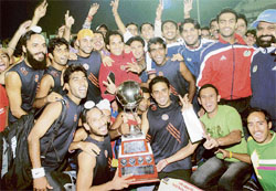 Winners Indian Oil players pose with trophy after winning the 24th Indian Oil Surjit hockey tournament in Jalandhar