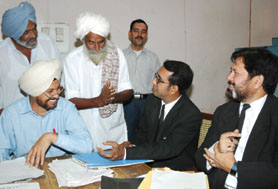 Additional civil judge Nirmal Singh listening to the problems of the petitioners at the Lok Adalat in Bathinda on Saturday.