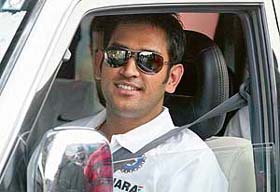 India's captain Mahendra Dhoni sits in a car after the cricket team's arrival in Lucknow