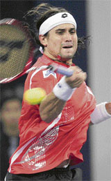 David Ferrer of Spain hits a return to compatriot Rafael Nadal at the Masters Cup tennis tournament in Shanghai on Tuesday.