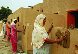 Women decorating the Heritage Village with traditional art in Bathinda.