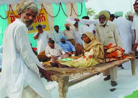 A woman being carried to meet Deputy Commissioner during a Sangat Darshan programme held at village Jodhpur Romana in Bathinda