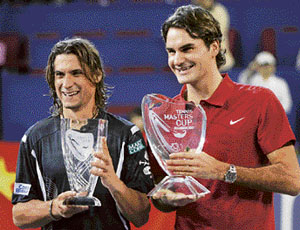 Roger Federer of Switzerland (R) and David Ferrer of Spain pose with their trophies as Federer wins and Ferrer finishes second at the Masters Cup tennis tournament in Shanghai on Sunday.