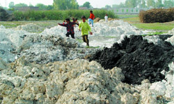 Children playing in the hazardous industrial waste at Rupana village