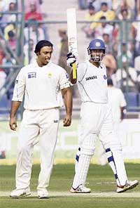Wasim Jaffer acknowledges the crowd on completing his fifty as Pakistan�s Shoaib Akhtar looks on during the Delhi Test. 