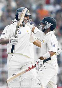 Misbah-ul-Haq (L) hugs Kamran Akmal after completing his century during the third day of the second Test against India at the Eden Gardens in Kolkata on Sunday.