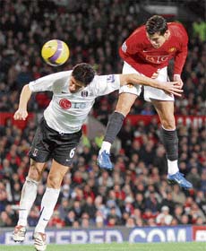 Cristiano Ronaldo (R) of Manchester United heads his second goal past Dejan Stefanovic of Fulham during the Premier League match on Monday at Old Trafford, Manchester