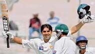 Misbah-ul-Haq celebrates with his team mate Yasir Arafat (2nd R) after completing his century against India on the fourth day of their third and final Test in Bangalore. 