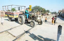 A tractor-trolley crossing an unmanned railway crossing in Amarpura Basti, Bathinda.