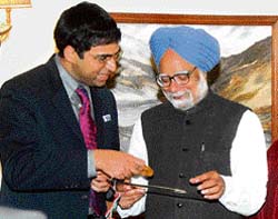 Viswanathan Anand shows trophy he won at World Chess Championship to Dr Manmohan Singh in New Delhi on Friday.