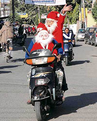 With Christmas round the corner, these youths dressed as Santa Claus take a ride in the Rani ka Bagh area in Amritsar on Saturday. 
