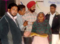 An old woman receiving shawl in Maluwala village of Ferozepur district at a programme organised under the banner of The Hope, an NGO, to help the needy as part of Christmas celebrations. As many as 80 shawls and blankets were distributed to the old and widows.