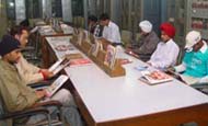 Readers engrossed in reading magazines at the library in Bathinda. 