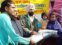 PPCC general secretary Parminder Singh Pinki distributing aid to the needy. 