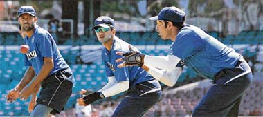 Wasim Jaffer (L) and Rahul Dravid (C) watch as V. V. S. Laxman takes the ball during a training session at the Sydney Cricket Ground