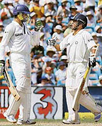 Harbhajan Singh (L) is congratulated by Sachin Tendulkar on completing his fifty during the third day of the second Test against Australia in Sydney on Friday.