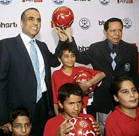 Information and broadcasting minister and All-India Football Federation president Priya Ranjan Dasmunshi (R) and CMD Bharti Enterprises Sunil Mittal pose with children at a press conference in New Delhi on Friday.
