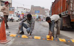 Disciplining Traffic: Reflector speed-breakers being installed on a congested road in Bathinda