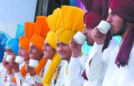 A bhangra team members sipping tea at the sports stadium in Bathinda on Sunday.