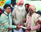 DIG Jitendra Jain presenting a cheque to a person at the de-addiction camp in Behman Deewana village on Sunday.