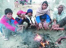 Residents sitting around bonfire to beat the chill in Bathinda on Tuesday. 