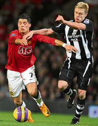 Cristiano Ronaldo (L) vies with Damien Duff during their Premier League match in Manchester on Saturday.