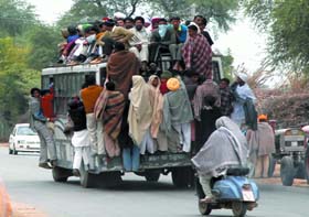 Devotees on their way to Maghi Mela in Muktsar, travel precariously on a bus near Doda .