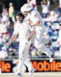 Andrew Symonds (L) is congratulated by Stuart Clark after he took the wicket of Rahul Dravid in Perth.