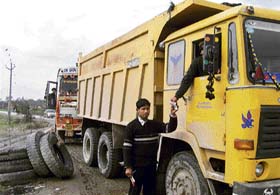 An employee of the mining contractor for Siunty village collects royalty from a truck at a naka at Kiri village in Gurdaspur on Sunday. 