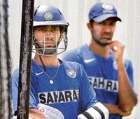 Dinesh Karthik (L) waits for his turn to bat in nets as Wasim Jaffer looks on during a training session at the Adelaide Oval stadium.