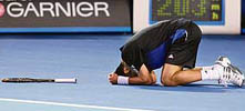 Serbian player Novak Djokovic drops to his knees as he celebrates victory over Federer.