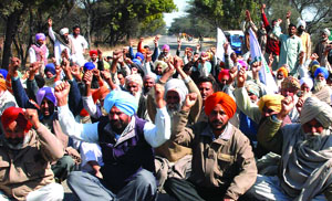 Farmers block traffic on the Bathinda-Chandigarh highway in protest near the GHTP on Tuesday.