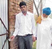 Amandeep Singh, grandson of freedom fighter Tarlok Singh Attari, shows the lock put on a tube well house following a land dispute at Attari on Friday. 