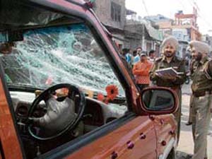 A policeman inspects the damaged car of the groom in the Haripura locality of Amritsar on Sunday.