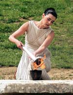Actress Maria Nafpliotou in the role of the ancient high priestess lits the torch with sacred flame of the Beijing 2008 Olympics to pass it to the first torchbearer, Alexandros Nikolaidis in ancient Olympia in the dress rehearsal of the ritual on Saturday.