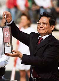 Chinese Olympic Committee president Liu Qi holds a carrier with the Olympic flame on Sunday at the Panathinaiko stadium in Athens during the handover ceremony to China for the 2008 games in Beijing