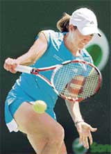 Justine Henin of Belgium returns a shot to Elena Vesnina of Russia during a fourth round match at the Sony Ericsson Open in Key Biscayne, Florida,