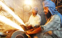 Blacksmiths sharpening tools as harvesting season is round the corner