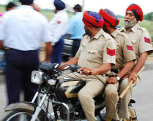 Three policemen riding a motorcycle cock a snook at traffic rules on the Bathinda-Badal road on Thursday. 