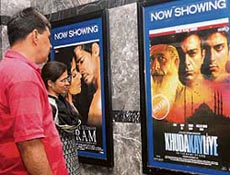 A couple take a look at the poster of Pakistani film �Khuda Ke Liye� (In The Name of God) at a cinema hall in New Delhi on Friday.
